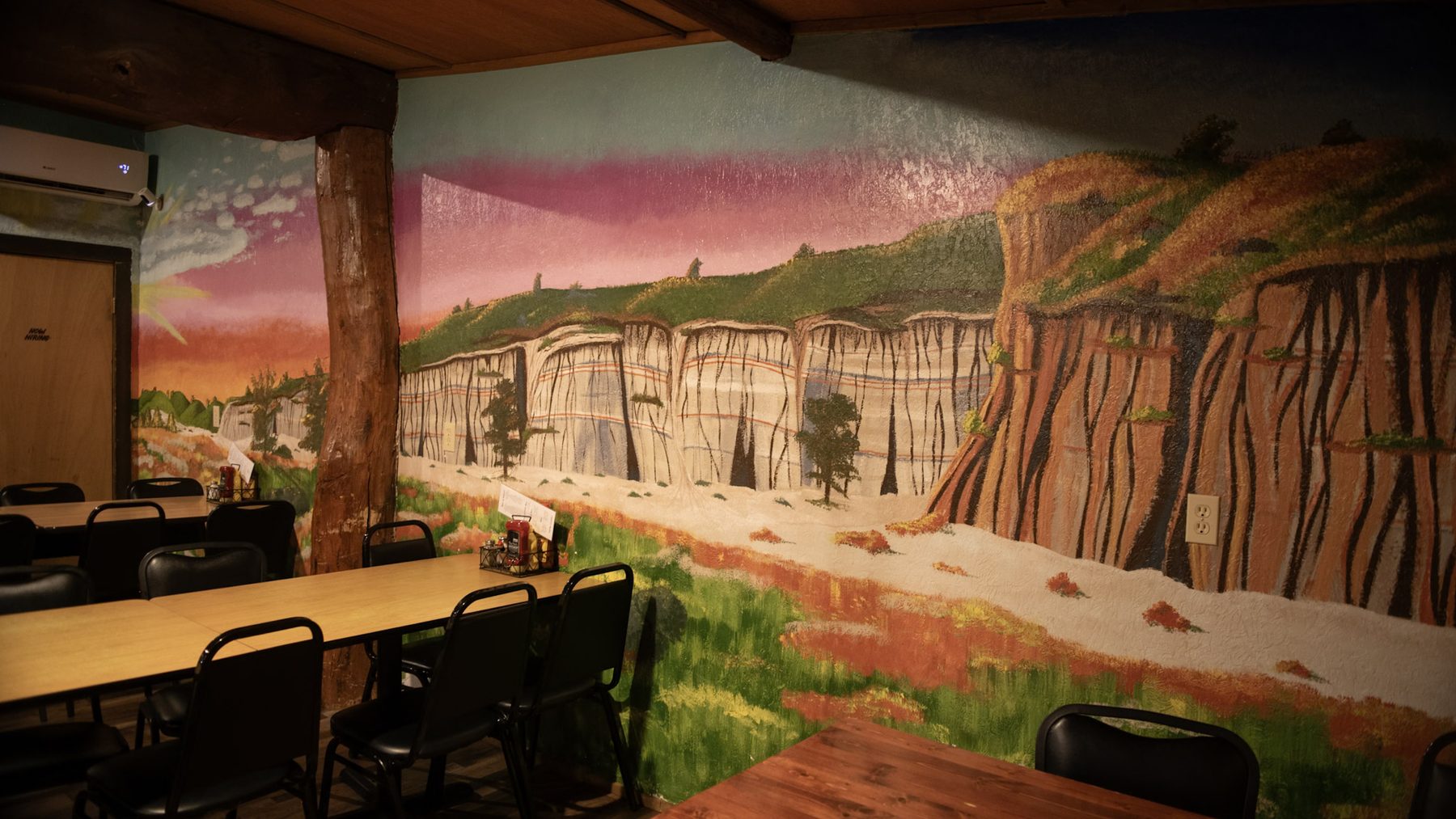 Rhoda Dutchak's hand-painted Badlands mural filling the back dining room wall at Burly's Roughrider